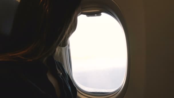 飛行機の窓からの景色を楽しみ、それを閉じる幸せなリラックスした乗客の女性の大気のクローズアップショット. — ストック動画
