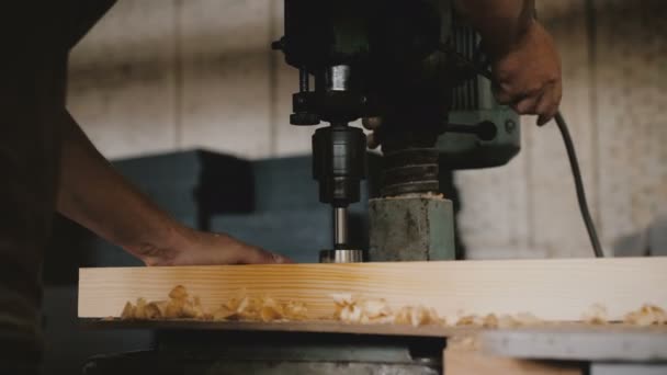 Primo piano mani maschili foratura assi di legno con macchina utensile professionale in una fabbrica. Uomo falegname al lavoro rallentatore. — Video Stock