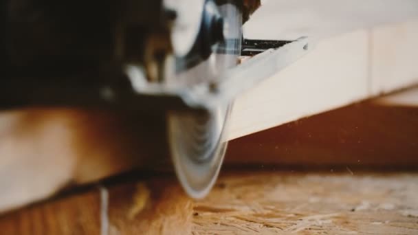 Удивительный крупный план, фокус смещается на роторную пилу аккуратно распиливая кусок дерева, плотник за работой замедленной съемки. — стоковое видео