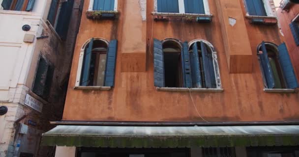 Fotografia de fundo, câmera lentamente desliza por belo edifício vermelho histórico velho com janelas abertas no canal de Veneza, Itália. — Vídeo de Stock