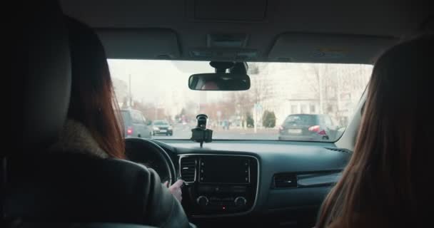 Городской стресс. Вид изнутри автомобиля, две женщины разговаривают за рулем личного автомобиля по оживленным мегаполисам. — стоковое видео