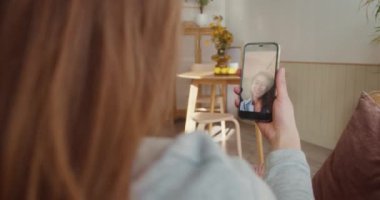 Video konferansı çevrimiçi. Omuz hizasında, mutlu kadın konuşmaları, akıllı telefon ekranında melez ırk dostlarına el sallamalar..