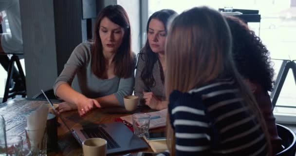 Teamwork en samenwerkingsconcept. Jonge blanke vrouwelijke baas maakt gebruik van laptop samen met collega 's in cafe. — Stockvideo