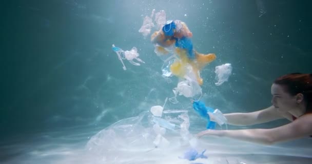 プラスチックの問題。映画撮影、水中スローモーションの下で単一の使用廃棄物を介して若い女性の観光客の水泳. — ストック動画