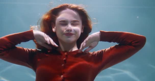 自然の美しさの概念。若いです美しいです赤毛の女性の映画のポートレート深いです水遅い動きの下で. — ストック動画