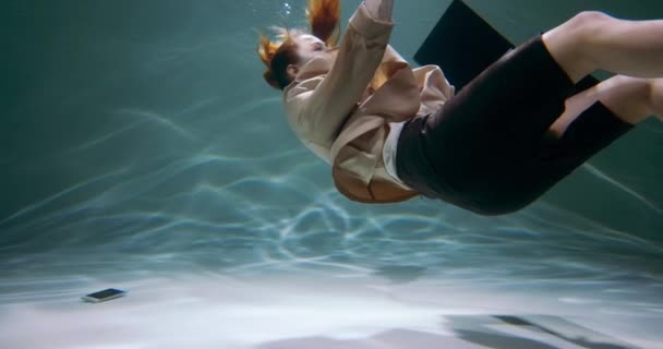 Mozgókép fiatal üzletasszony elsüllyed a víz alá, eldobja okostelefon lassított felvétel. Stressz és depresszió koncepció — Stock videók
