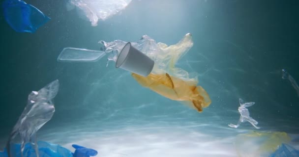 プラスチックごみ問題。スローモーション様々なシングルユース包装廃棄物が水の下に浮く汚染された海スローモーション. — ストック動画