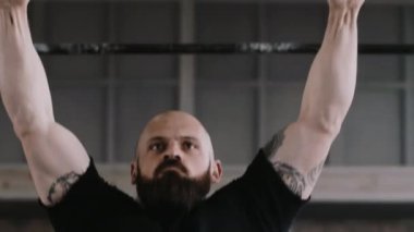 Spor salonunda antrenman yaparken barfiks çeken, atlayan, yakın plan sert, beyaz erkek sporcu. Sağlıklı yaşam tarzı kavramı