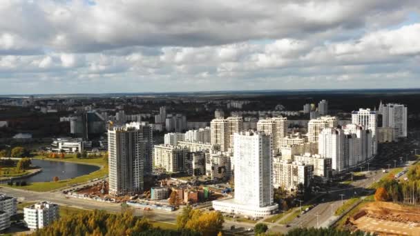 Drone volando sobre hermoso panorama de otoño megápolis de Minsk, Bielorrusia, bloques de torre de gran altura en construcción. — Vídeos de Stock