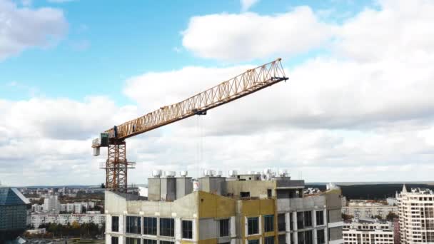 Drone volando cerca de la grúa de construcción durante el proceso de desarrollo del edificio de apartamentos de torre de gran altura. — Vídeos de Stock