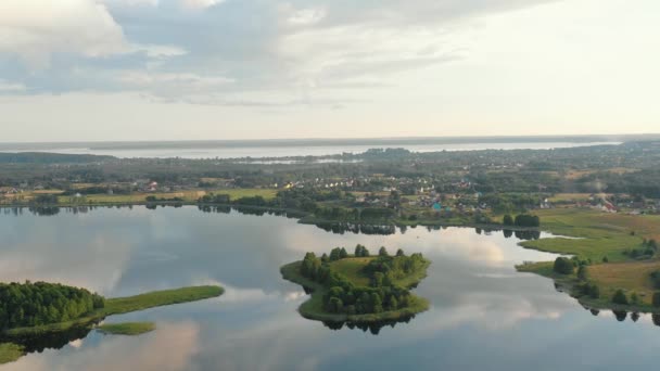 Fondo aéreo épico de grandes lagos tranquilos al amanecer, árboles y un pequeño pueblo pintoresco en el centro. Braslav, Belarús. — Vídeos de Stock