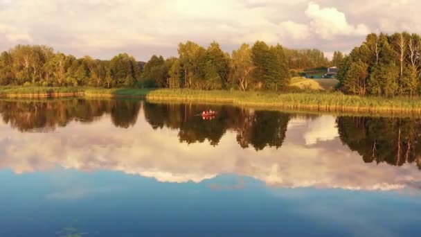 İnsansız hava aracı çocuklarla mutlu bir aileye doğru uçuyor. İnanılmaz yaz gündoğumu gölünde birlikte tekne gezintisinin tadını çıkarıyorlar.. — Stok video