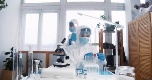 Médica de laboratório jovem focada em terno de proteção médica completa e trabalhos de escudo em nova vacina contra o coronavírus. — Vídeo de Stock