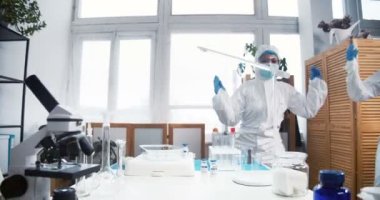 Başarıyı kutluyoruz. İki heyecanlı, mutlu kimya laboratuarı doktoru iş yerinde yengeç dansı yapıyor..