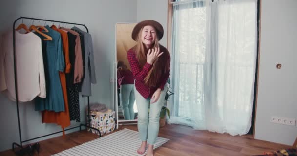 Linda jovem mulher loira caucasiana excitada dançando, olhando para a câmera experimentando novas roupas no grande quarto guarda-roupa. — Vídeo de Stock