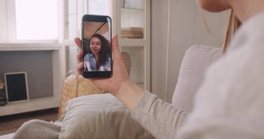 Kendini izole etme konusunda arkadaşlık. Omuz hizasında, kadın akıllı telefon web konferansında karışık ırk arkadaşıyla konuşuyor.