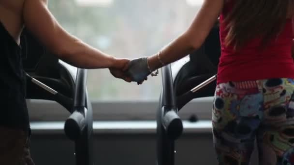 Uomini e donne si allenano insieme in palestra tenendosi per mano — Video Stock