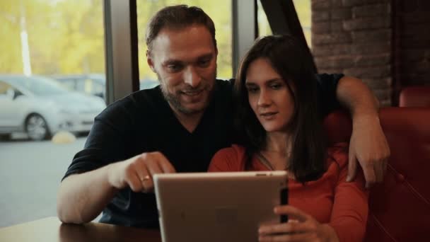 Pareja joven usando tableta digital. cafetería — Vídeos de Stock