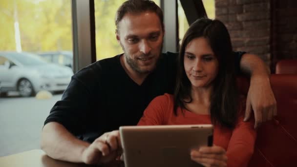 Νεαρό ζευγάρι χρησιμοποιώντας ψηφιακή δισκίο υπολογιστή. καφέ — Αρχείο Βίντεο