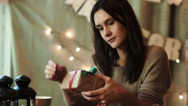 Mujer joven envolviendo regalos de Navidad en casa — Vídeo de stock