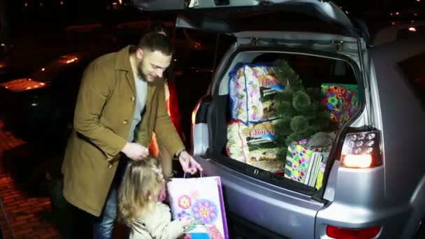 Familia pone regalos de Navidad y árbol en el coche — Vídeo de stock