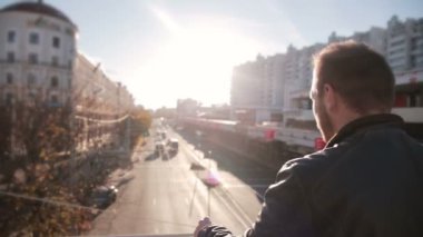 Günbatımında şehir trafiğinde adam bakar