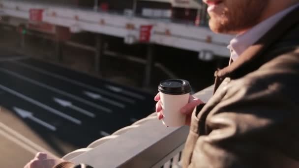 Man kijkt naar verkeer in de stad, drinken koffie — Stockvideo