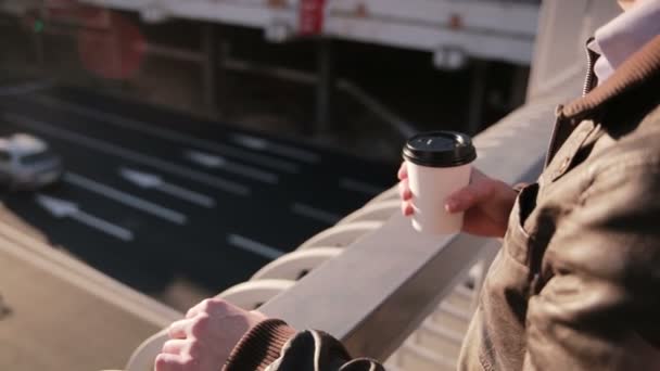 Мужчина смотрит на пробки в городе, пьет кофе — стоковое видео