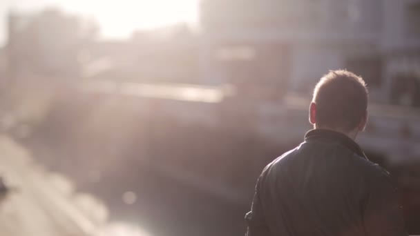 L'uomo guarda il traffico in città al tramonto — Video Stock