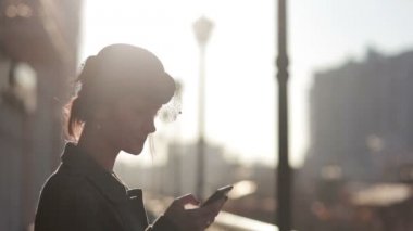 telefonda konuşurken bir örtü ile şapkalı kız