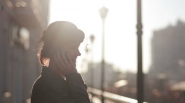 telefonda konuşurken bir örtü ile şapkalı kız