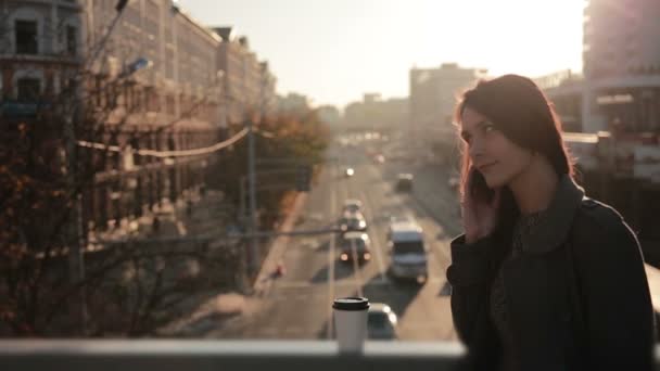 Красивая женщина разговаривает по телефону на городском мосту — стоковое видео