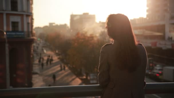 Hermosa joven mira a la ciudad — Vídeo de stock