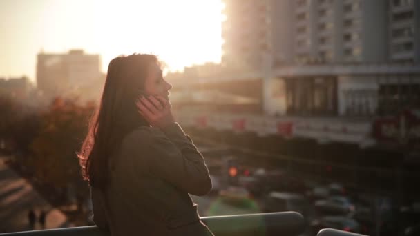 Mooie vrouw praten over de telefoon op een brug van de stad — Stockvideo