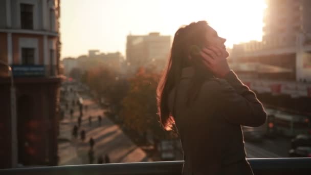 Pretty woman talking on the phone on a city bridge — Stock Video