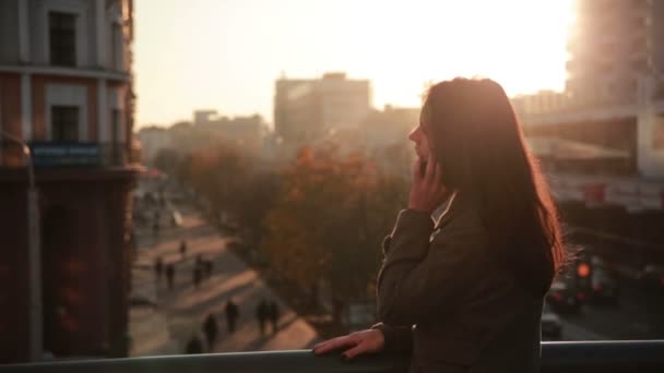 Bonita mulher falando ao telefone em uma ponte da cidade — Vídeo de Stock