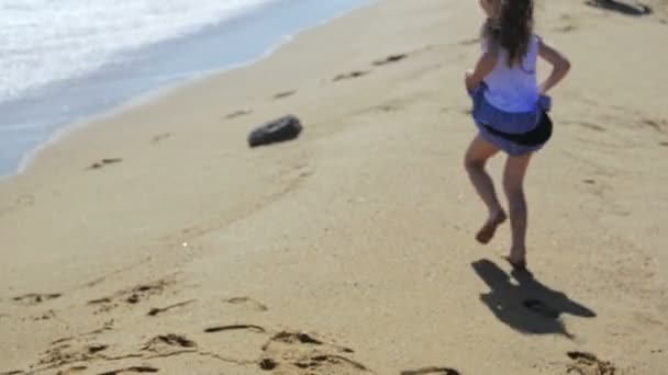 Menina brincando com ondas na praia — Vídeo de Stock