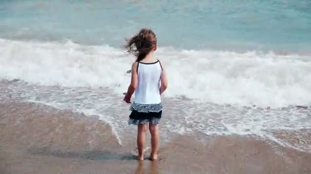 A kislány-játék a hullámokkal a strandon — Stock videók