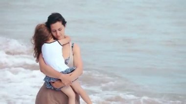 Anne ve kızı deniz sahilde öpüşme sarılmak