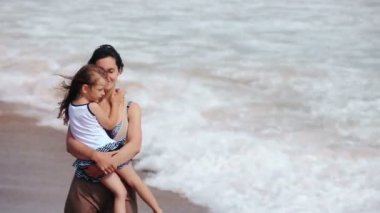 Anne ve kızı deniz sahilde öpüşme sarılmak