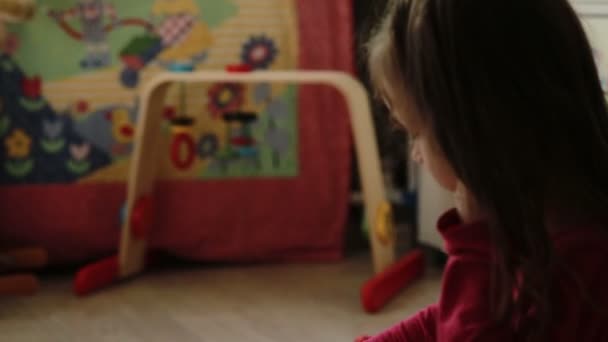 Χαριτωμένο κοριτσάκι παίζει με μπλοκ παιχνιδιών στο σπίτι — Αρχείο Βίντεο