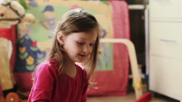 Cute little girl playing with toy blocks at home — Stock Video