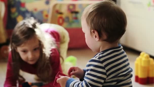 Kisfiú játszik a húga, a gyerekszobában — Stock videók