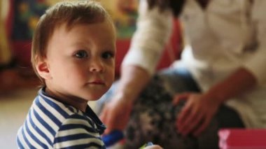 Onun bebek çocuk oyuncakları ile oynarken annesi