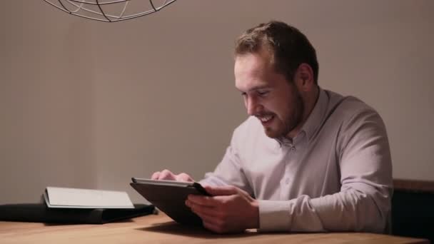 Молодой бизнесмен работает на планшете в кафе — стоковое видео
