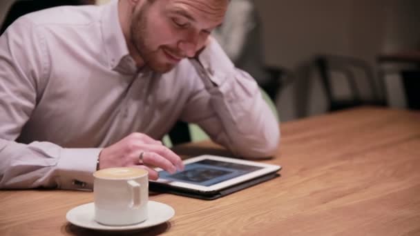 Jovem empresário trabalhando em tablet no café — Vídeo de Stock
