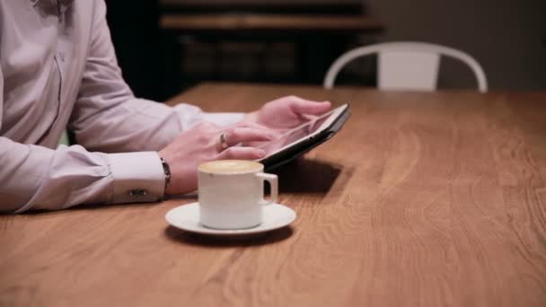 Νεαρός επιχειρηματίας που εργάζεται στο tablet στο καφέ — Αρχείο Βίντεο