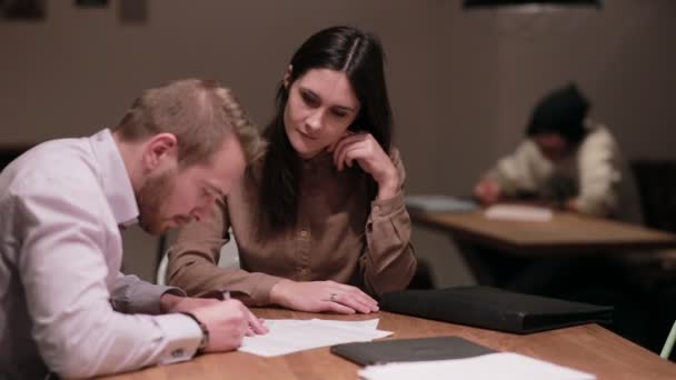 Мужчина и женщина работают с документами в кафе — стоковое видео