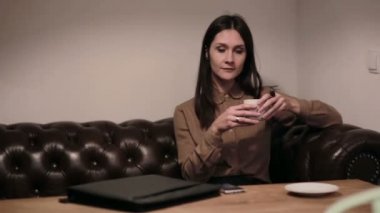 bir kafede telefonda konuşurken iş kadını