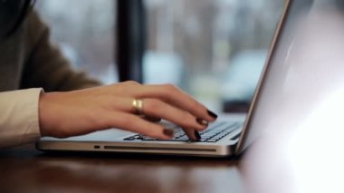 Kafede dizüstü bilgisayar üzerinde çalışan eller. Slayt sol